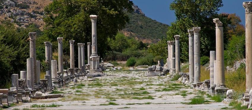 Two rows of standing columns lining a broad, level marble street in the lower city of Ephesus