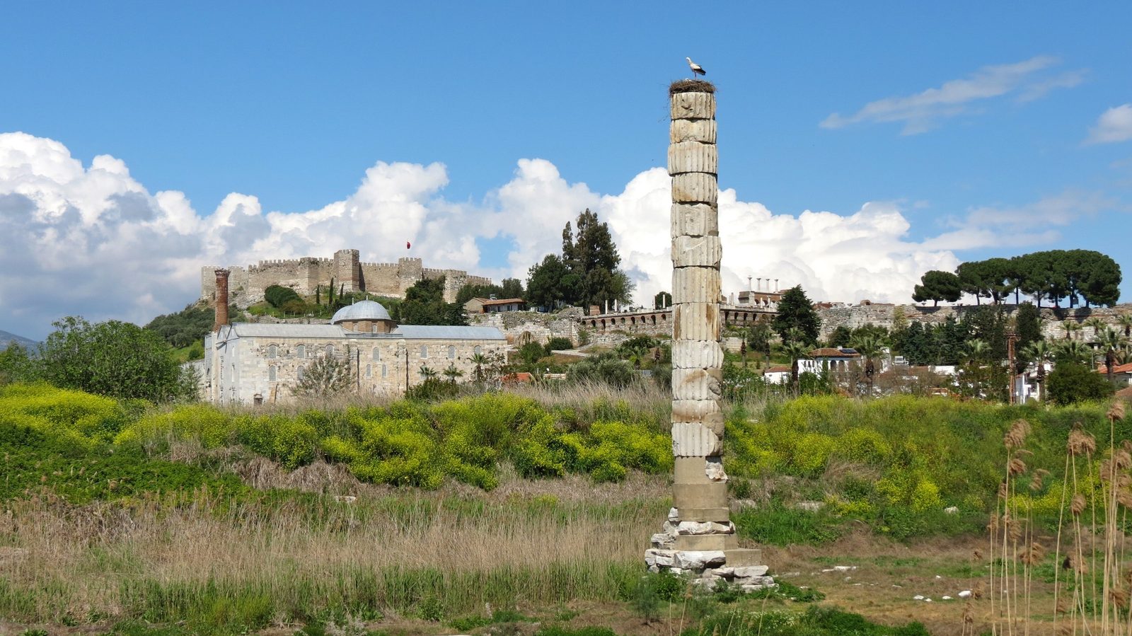 The single re-erected column of the Temple of Artemis with a stork on top, and behind it the İsa Bey Mosque and the walls of Ayasuluk Fortress on the hill at Selçuk